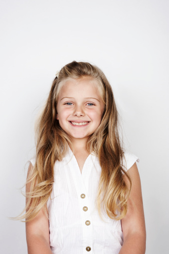 Portrait of cute girl give v-sign near eye. Smiling little girl posing over white background with copy space, close-up