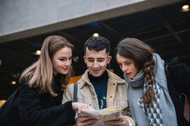 istock three young tourists looking at map together 1070727560