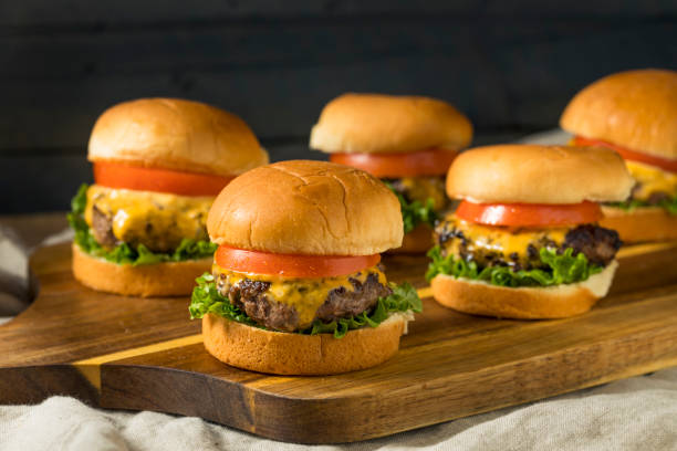 Homemade Cheeseburger Sliders with Tomato Homemade Cheeseburger Sliders with Tomato and Lettuce sliding photos stock pictures, royalty-free photos & images