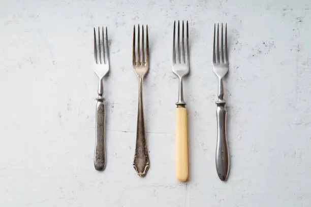 Various vintage forks on concrete background