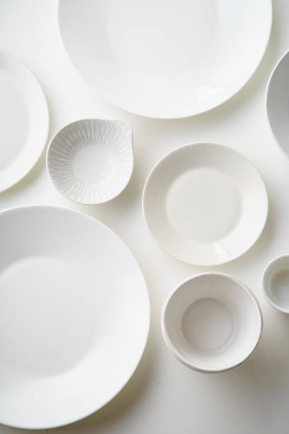 istock Porcelain plates of various form and size on white background. Overhead image, copy space. 1070737570