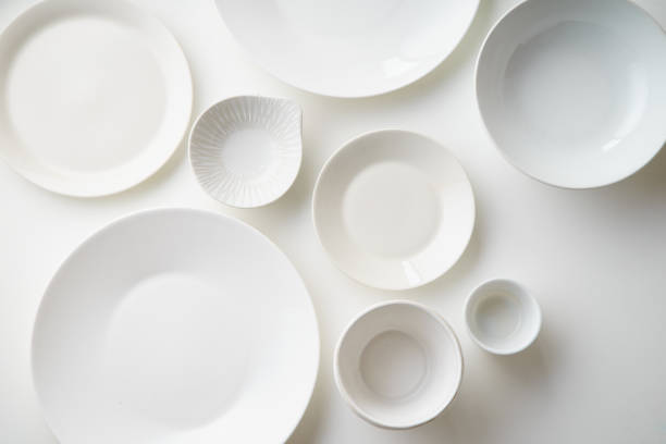 istock Porcelain plates of various form and size on white background. Overhead image, copy space. 1070737618