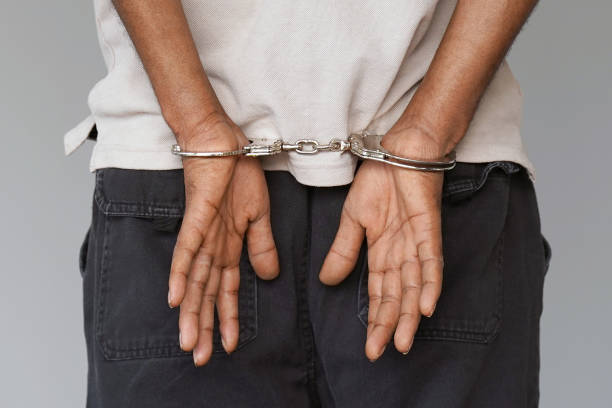 istock Criminal hands locked in handcuffs. Close-up view 1070745338