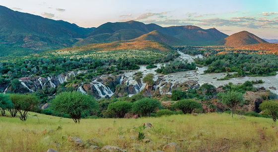 Epupa Falls on the Kunene River in Northern Namibia and Southern Angola border. Sunset sunlight with water mist. View from hill