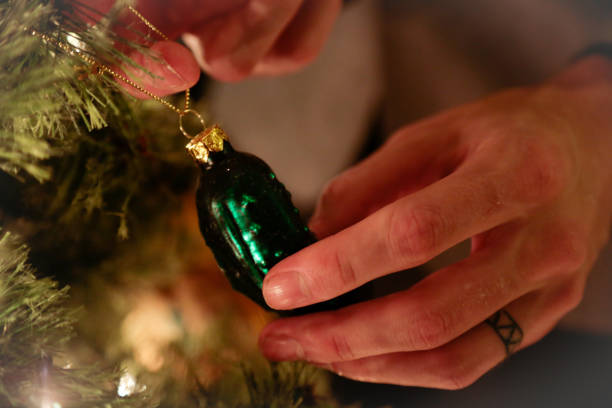 hanging a unique ornament on the christmas tree - cucumber pickled imagens e fotografias de stock