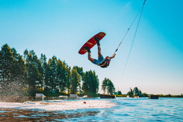 молодой человек вейкбординг на озере - wakeboarding waterskiing water ski sunset стоковые фото и изображения