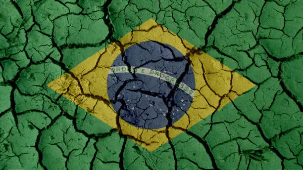 Political Crisis Or Environmental Concept: Mud Cracks With Brazil Flag