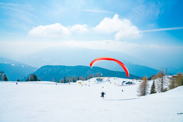 gleitschirm über die ski pisten in österreichische alpen. - paragliding sport austria parachuting stock-fotos und bilder
