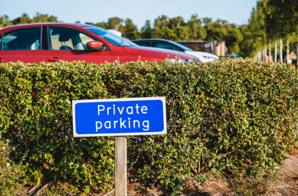 Blue colored sign PRIVATE PARKING at the entrance of car park stock photo