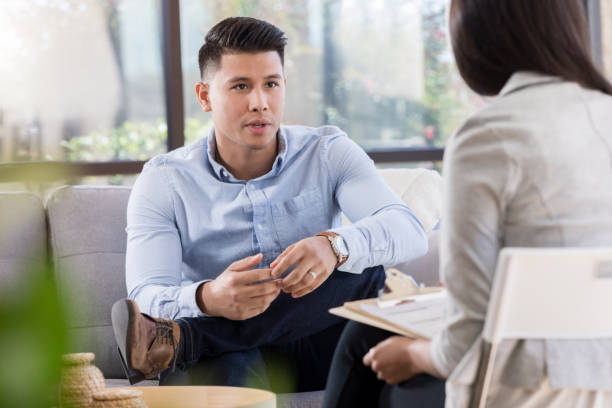 istock Concerned young man talks with female counselor 1070775072