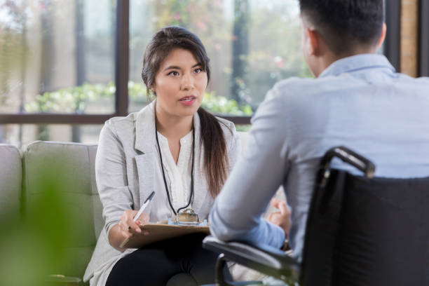 istock Serious therapist counsels wheelchair-bound man 1070775092