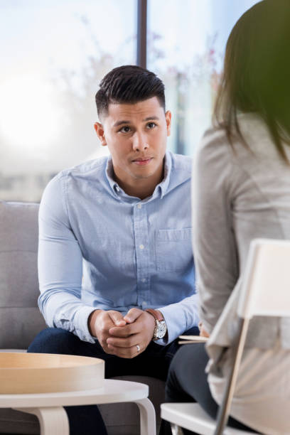 Serious young man talks with counselor
