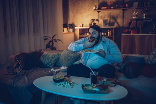istock Fat man watching basketball game on TV 1070796554