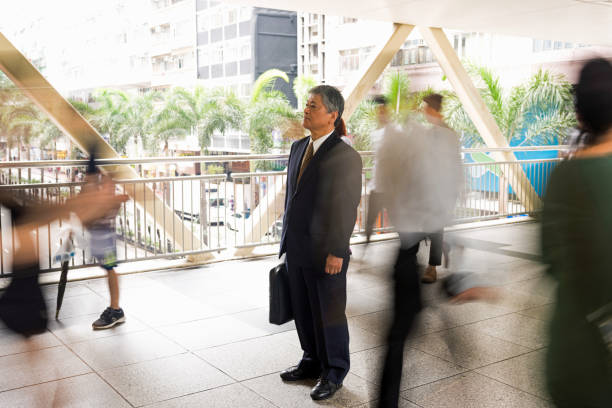 istock Senior Asian businessman standing out from the crowd 1070799012