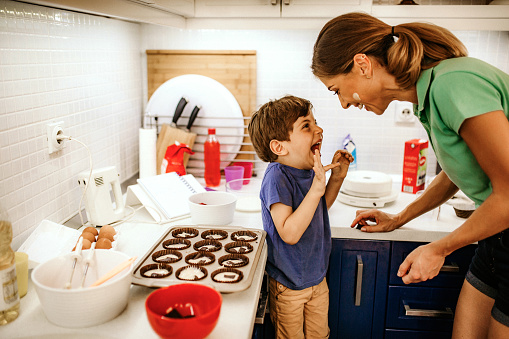 Mother and son making muffins in kitchen