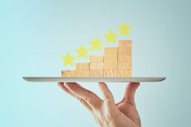 Waiter hand holding a five star goal increase rating or ranking , concept of classification and evaluation .