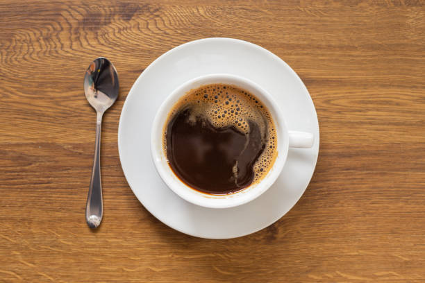 istock coffee in white cup on wood table, top view 1070825244