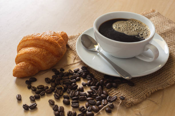 istock coffee in white cup with coffee bean and croissant on wood table 1070827736