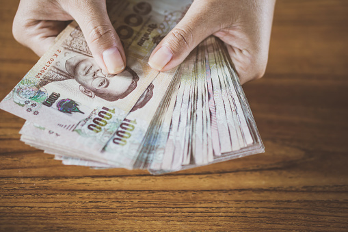 mano de mujer contando dinero 1000 tailandés photo