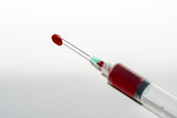 istock Syringe with blood on white background 1070843942