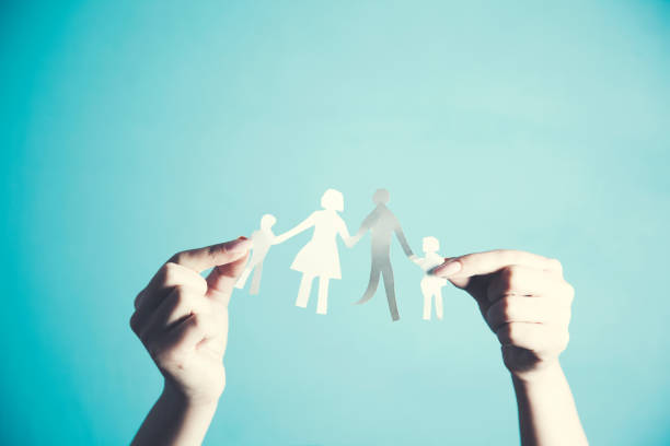 istock womans cupped hands showing paper man family 1070844162