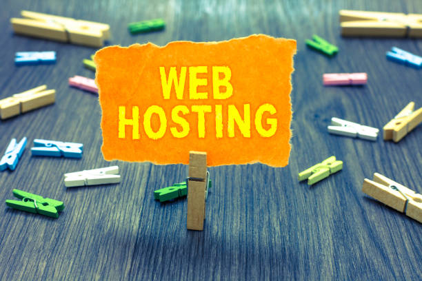istock Conceptual hand writing showing Web Hosting. Business photo text The activity of providing storage space and access for websites Clothespin holding orange paper note clothespins wooden floor. 1070855774