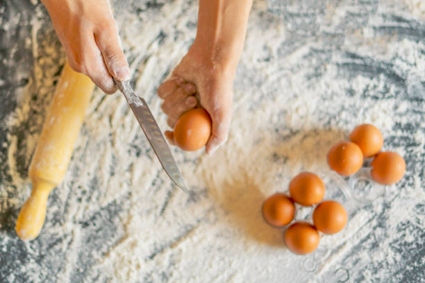 istock chef cook holding egg and preparing dough on the table top view f 1070856150