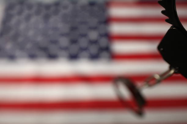 istock handcuffs on the background of the US flag 1070866542