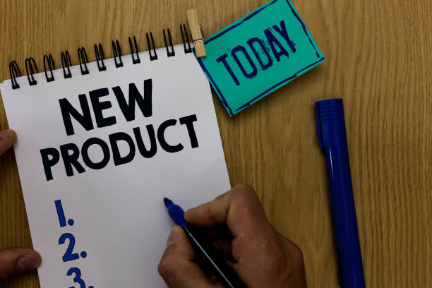 istock Word writing text New Product. Business concept for goods and services that differ in their characteristics Man holding marker notebook clothespin reminder wooden table cup coffee. 1070871978