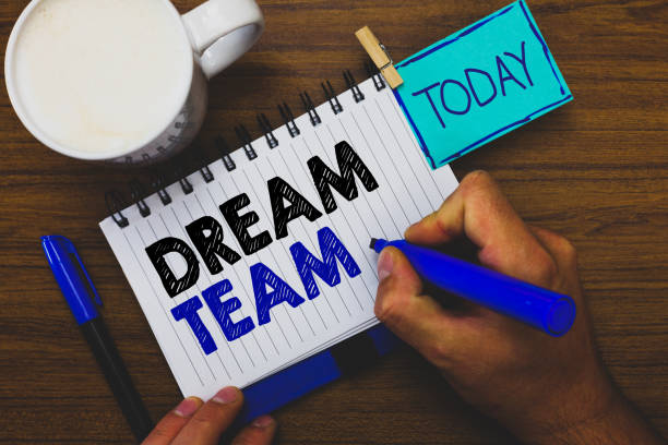 istock Word writing text Dream Team. Business concept for Prefered unit or group that make the best out of a person Man holding marker notebook clothespin reminder wooden table cup coffee. 1070872002