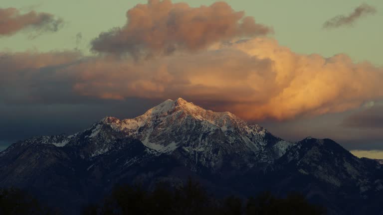 Time Lapse of the Snowcapped Wasatch Mountains above Salt Lake City, UT at Sunrise/Sunset with a Dramatic Cloudscape