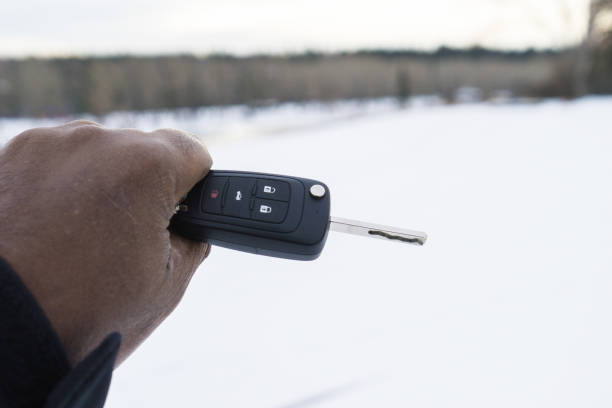 man holding car key in winter - cold and freezing