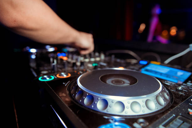 istock DJ turntable console mixer controlling with two hand in concert nightclub stage. 1070894064