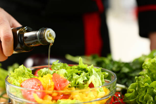istock Cook holds bottle in hand and trickles olive 1070896008
