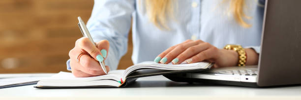 istock Female arm in suit hold silver pen making note 1070900062