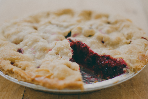 A close-up of a saskatoon berry pie in a tin pie plate