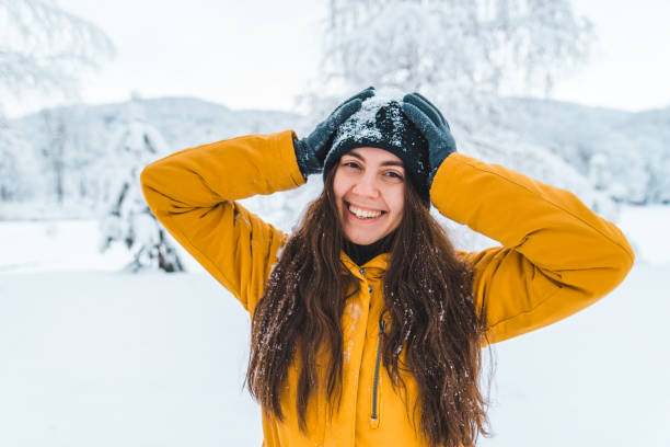 istock smiling woman portrait outdoors snow on hat 1070902024