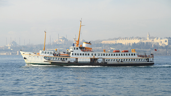Istanbul, Turkey- November 01, 2011: People on a ferry throwing bread crumbs to seagulls.