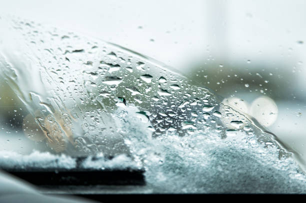 istock Snow-covered car windshield with melted snow drops and windshield wipers. Copy space. 1070908120