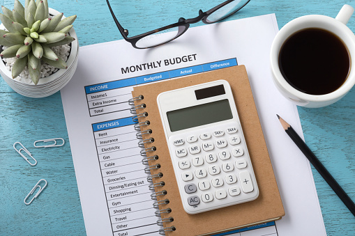 Presupuesto mensual con la calculadora blanco sobre azul mesa photo