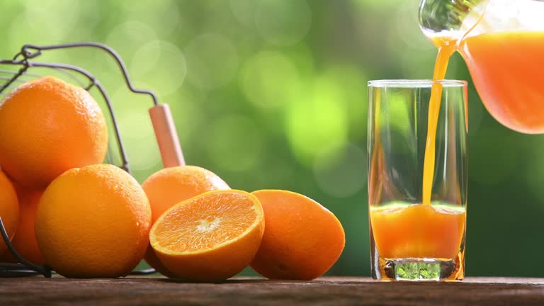 Fresh orange juice pouring into glass