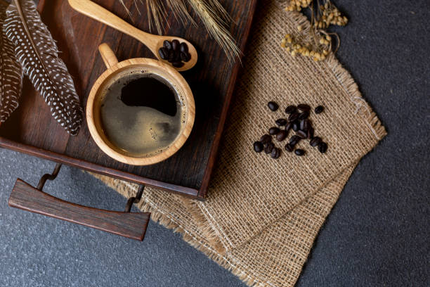 istock coffee in wooden cup and seed with sackcloth on black table background. 1070919512