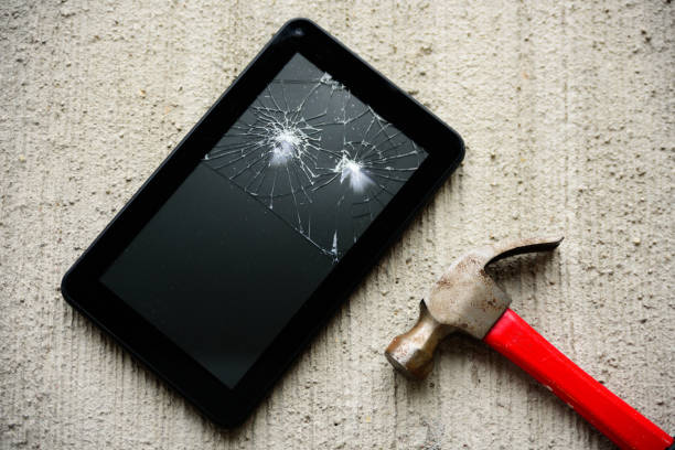 istock Broken tablet with hammer near it 1070929624