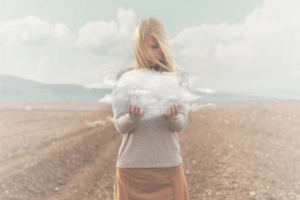 momento surrealista, mujer sosteniendo en sus manos una nube suave - creativity surprise thinking inspiration fotografías e imágenes de stock