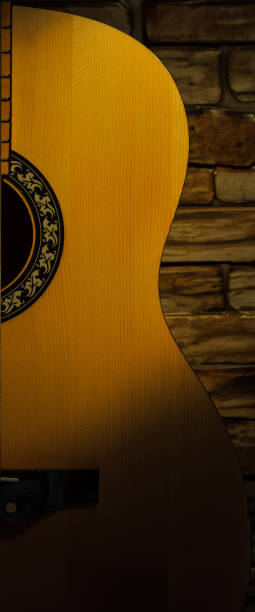 istock Acoustic guitar illuminated by a spotlight against a brick wall. 1070932144