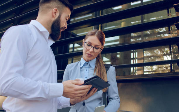 istock Two business people browsing on tablet computer outdoors 1070937878