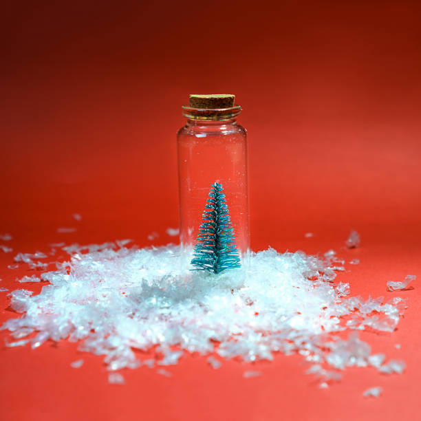 istock Flat lay Christmas tree with snow in small glass jar on red background. Creative winter New Year background. top view. Snowy christmas trees on red background. Minimal New Year concept. 1070940612