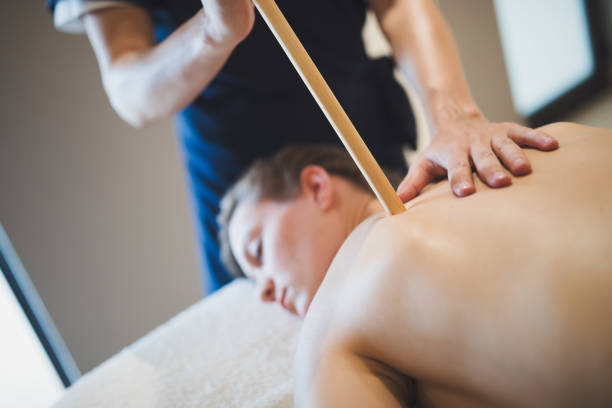 istock Masseur massaging masseuse at wellness resort 1070941406