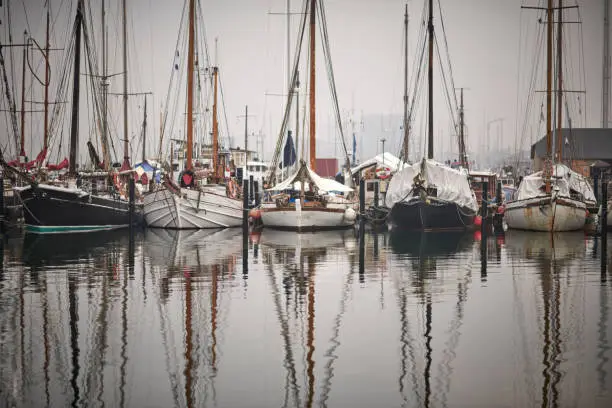 different sail wooden sail boats in a harbor