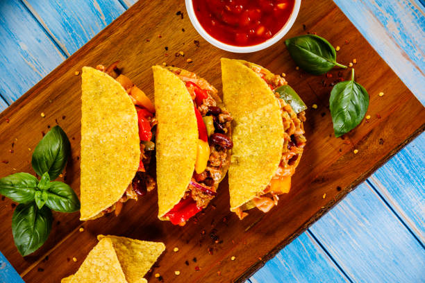 Tacos on cutting board on wooden table